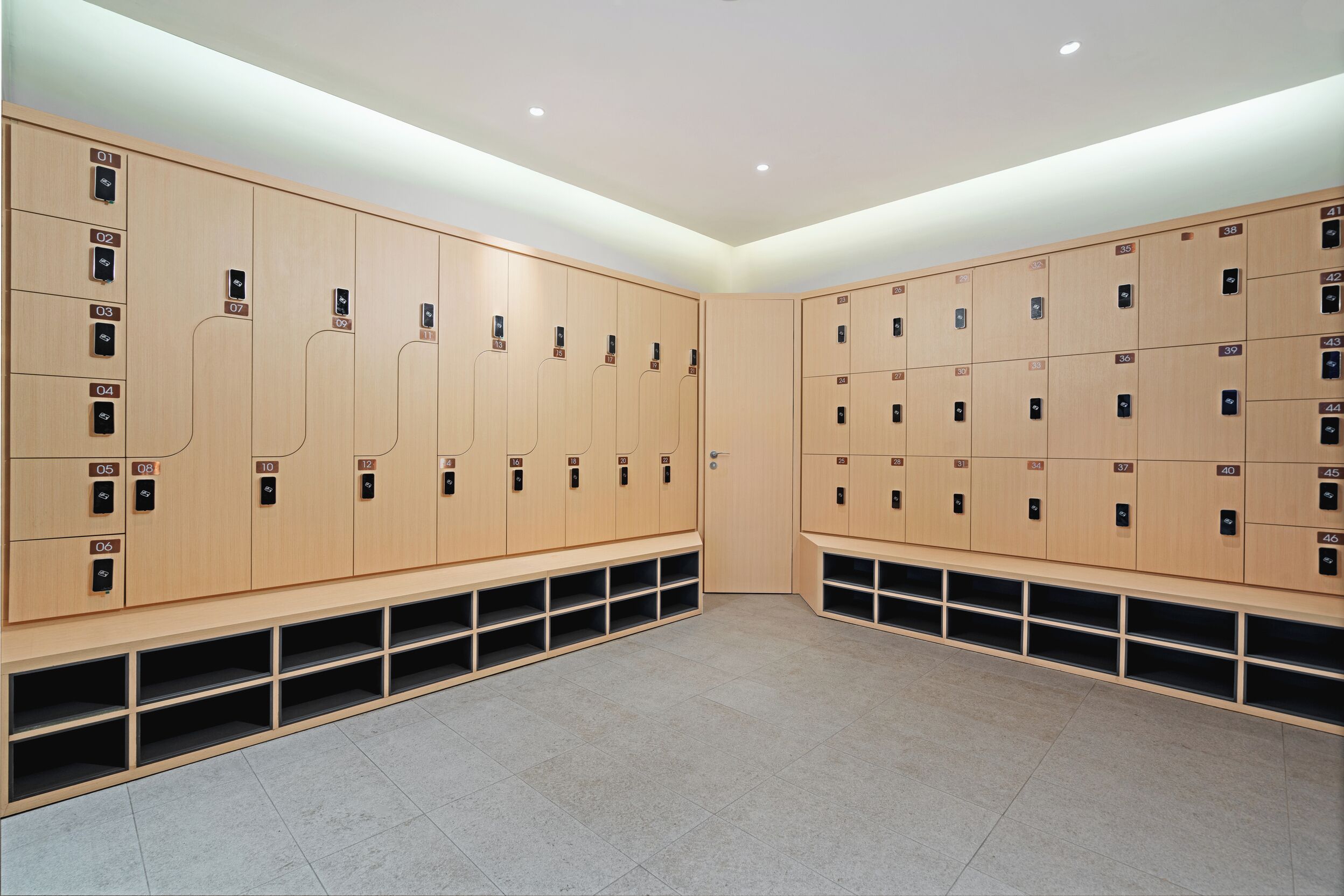 A modern locker room with multiple wooden lockers, each marked with a number.