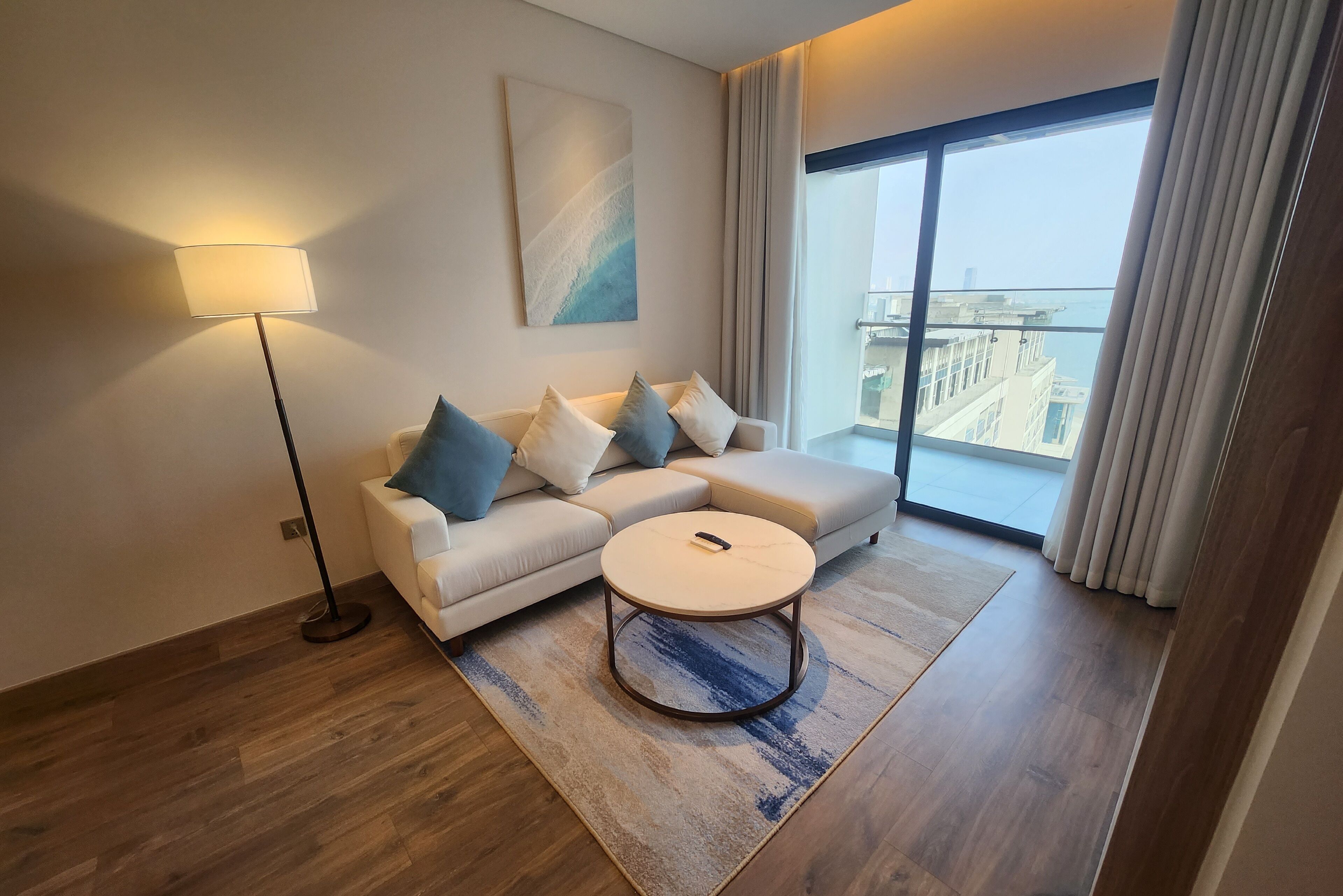 A modern living room with a sofa, coffee table, and floor lamp.