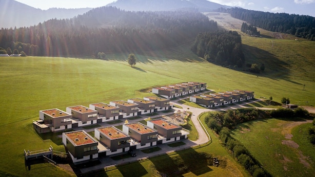 A modern residential complex with multiple buildings featuring flat roofs and a central courtyard.