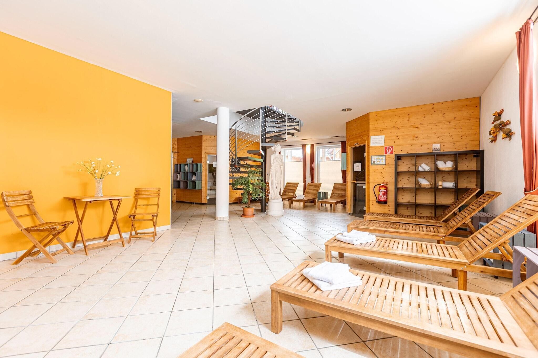 Um saguão de hotel com mobiliário de madeira, uma escadaria em espiral e uma área de recepção.