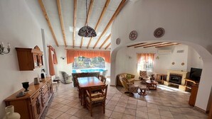 Un salón amplio con una mesa de comedor de madera, sofás y una chimenea.