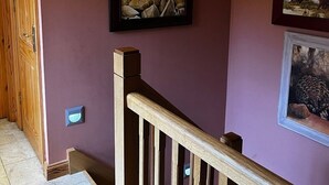 Een trap met houten leuningen en een paarse muur.