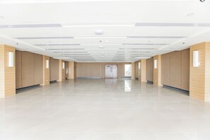 Un interior espacioso y moderno con techo alto, iluminación empotrada y suelo pulido.