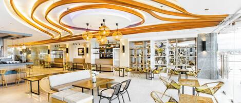 A modern cafe with a central seating area, wooden ceiling design, and a view of the city.