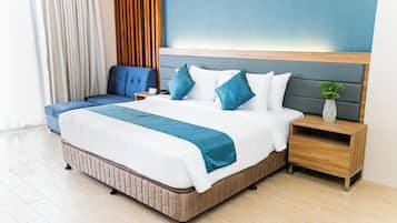 Moderni hotellihuone, jossa on suuri sänky, yöpöydät, yövalaisin ja näkymä ulos.
