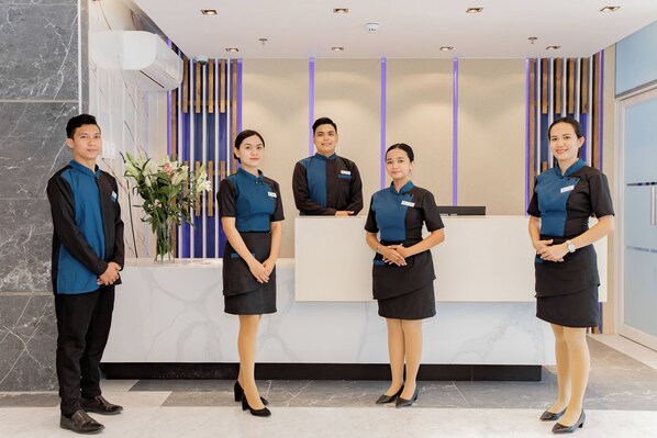 A reception desk with five staff members standing in front. - Hotel Dulcee (Naga City)