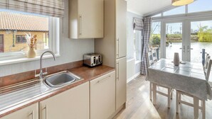 A kitchen with a sink, a toaster, and a window overlooking a house. - 2 bedroom accommodation in Swinethorpe, Nr Lincoln (Swinethorpe, Nr Lincoln)