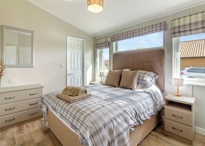 A bedroom with a bed, bedside tables, a dresser, a mirror, and a window with blinds. - 2 bedroom accommodation in Swinethorpe, Nr Lincoln (Swinethorpe, Nr Lincoln)