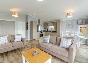 A modern living room with a sofa, coffee table, and dining area. - 1 bedroom accommodation in Swinethorpe, Nr Lincoln (Swinethorpe, Nr Lincoln)