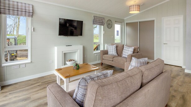 A living room with a fireplace, a television, and a sofa. - 2 bedroom accommodation in Swinethorpe, Nr Lincoln (Swinethorpe, Nr Lincoln)