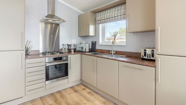 A modern kitchen with stainless steel appliances, wooden countertops, and a window with blinds. - 1 bedroom accommodation in Swinethorpe, Nr Lincoln (Swinethorpe, Nr Lincoln)