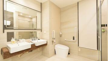 Un baño moderno con dos lavamanos, un inodoro y una cabina de ducha de vidrio.