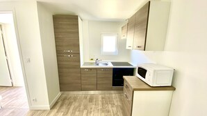 Una cocina moderna con armarios de madera, lavavajillas integrado y microondas.