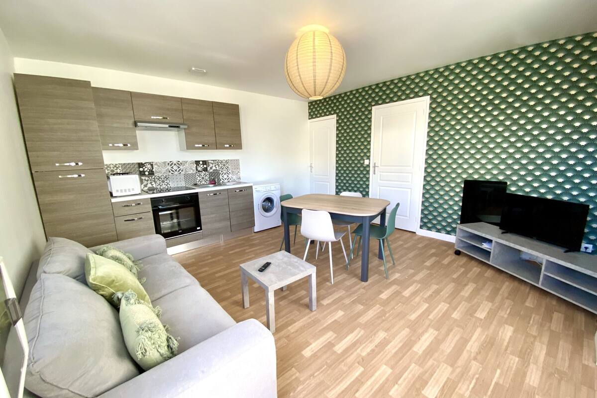 Una sala de estar moderna con sofá, mesa de comedor y mueble para televisión.