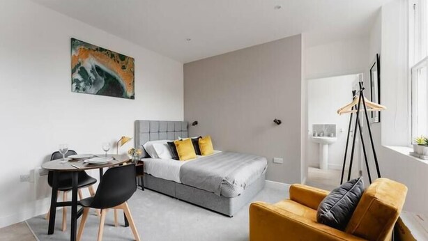 Una camera da letto moderna con un letto, un comodino e una sedia.