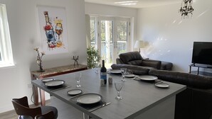 Uma cozinha moderna com área de jantar, um sofá e uma televisão.