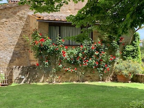 A stone building with a garden in front. - Entire home hosted by Agriturismo Castello Di Montozzi (Pergine Valdarno)