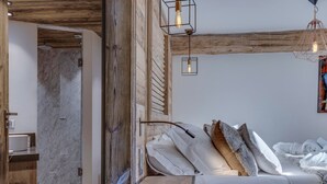 Une chambre à coucher avec une tête de lit en bois, un lit recouvert de draps blancs et une table de chevet.