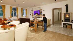 A modern living room with a fireplace, wooden flooring, and a television. - Přehrada Souš by Interhome (Desná v Jizerských horách)