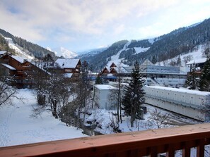 Ein verschneites Bergdorf mit Holzhäusern und einer Bahngleis.