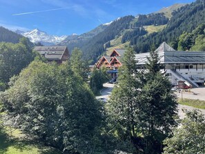 A mountain resort with traditional wooden buildings and a modern hotel. - 2-room apartment for 4 in Méribel center with balcony and WIFI (Méribel)