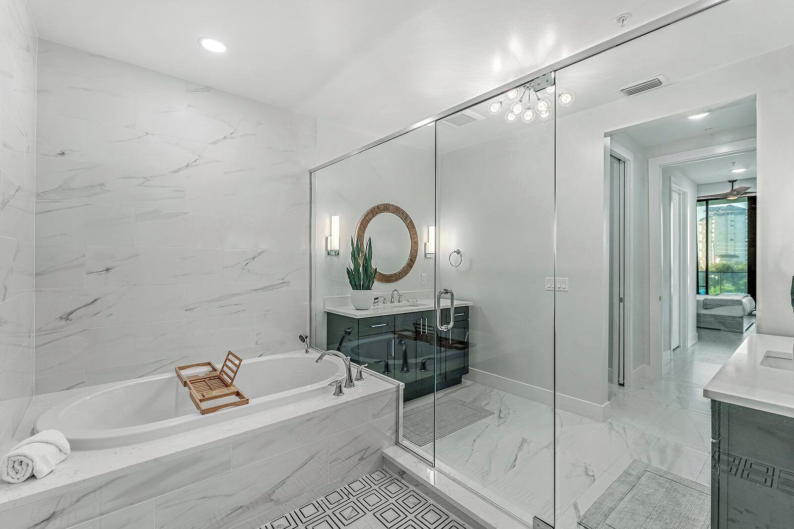 A modern bathroom with a large bathtub, a glass shower enclosure, and a large mirror.