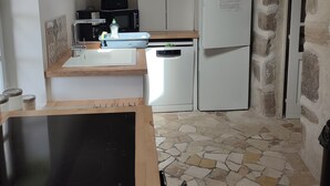 Une cuisine compacte équipée d’un four à micro-ondes, d’une cuisinière et d’un réfrigérateur.