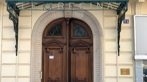 Eine doppelte Holztür mit einem Schild darüber, auf dem 'FORECINA' steht.