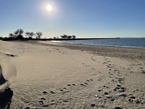 A sandy beach with footprints and a clear sky.