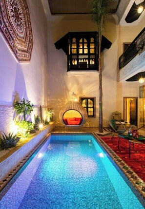 A pool area with a hanging chair, a staircase, and a decorative wall. - Riad Chamade - Exclusive for your group, up to 12 pers, Medina Marrakech (Marrakech)