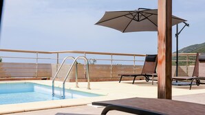 A rooftop pool area with a clear view of the surrounding landscape, including hills and a fence. - Elite Villa Elite Villa (Farinole)