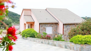 A building with a sloped roof, stone facade, and a small window. - Elite Villa Elite Villa (Farinole)