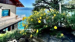 Un bâtiment moderne avec une façade en pierre, un balcon doté d’une piscine et une vue sur la mer.
