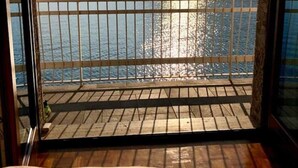 Une pièce avec une terrasse en bois et une vue sur un lac et des montagnes.