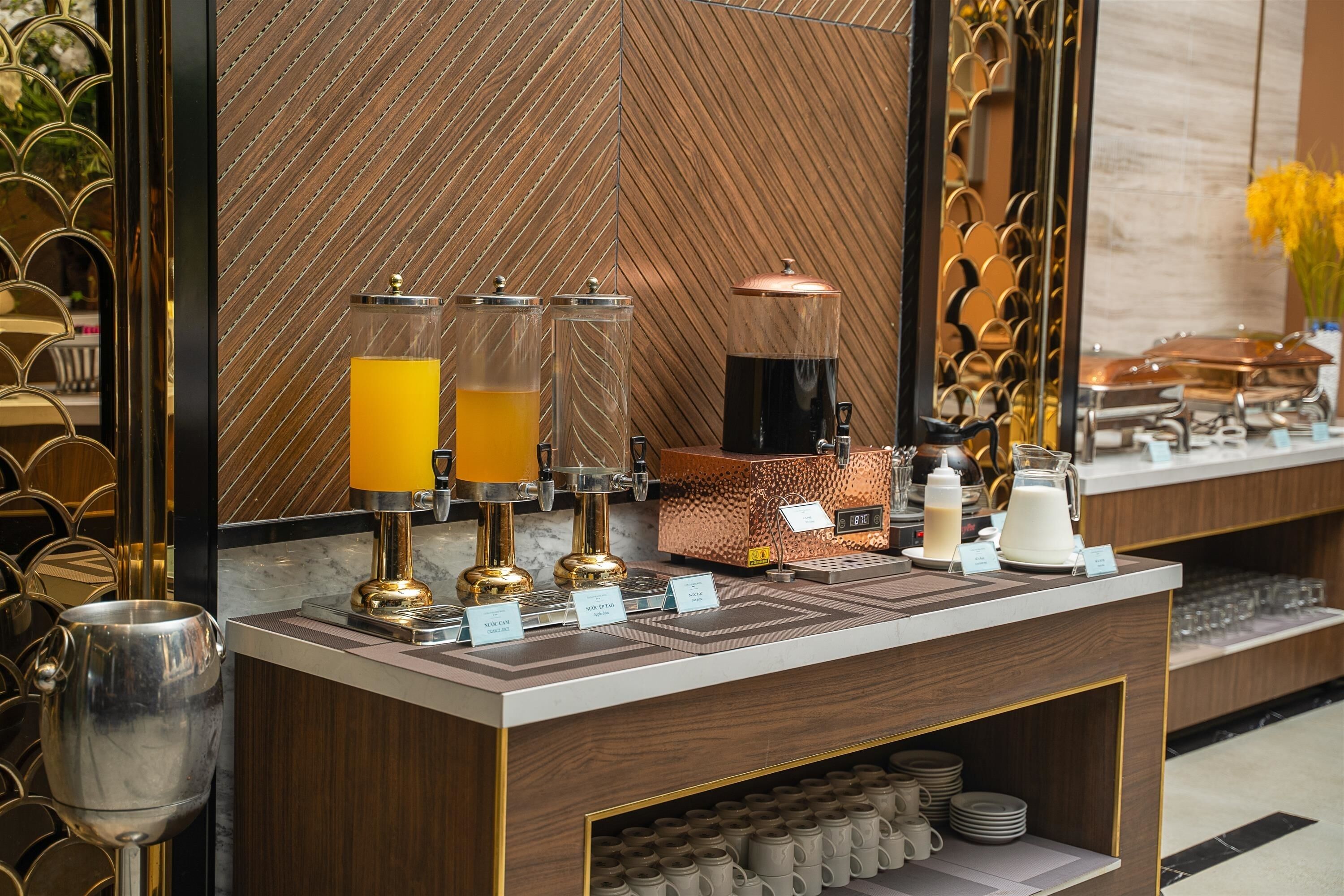 A breakfast bar with coffee and juice dispensers, a coffee machine, and a milk dispenser.