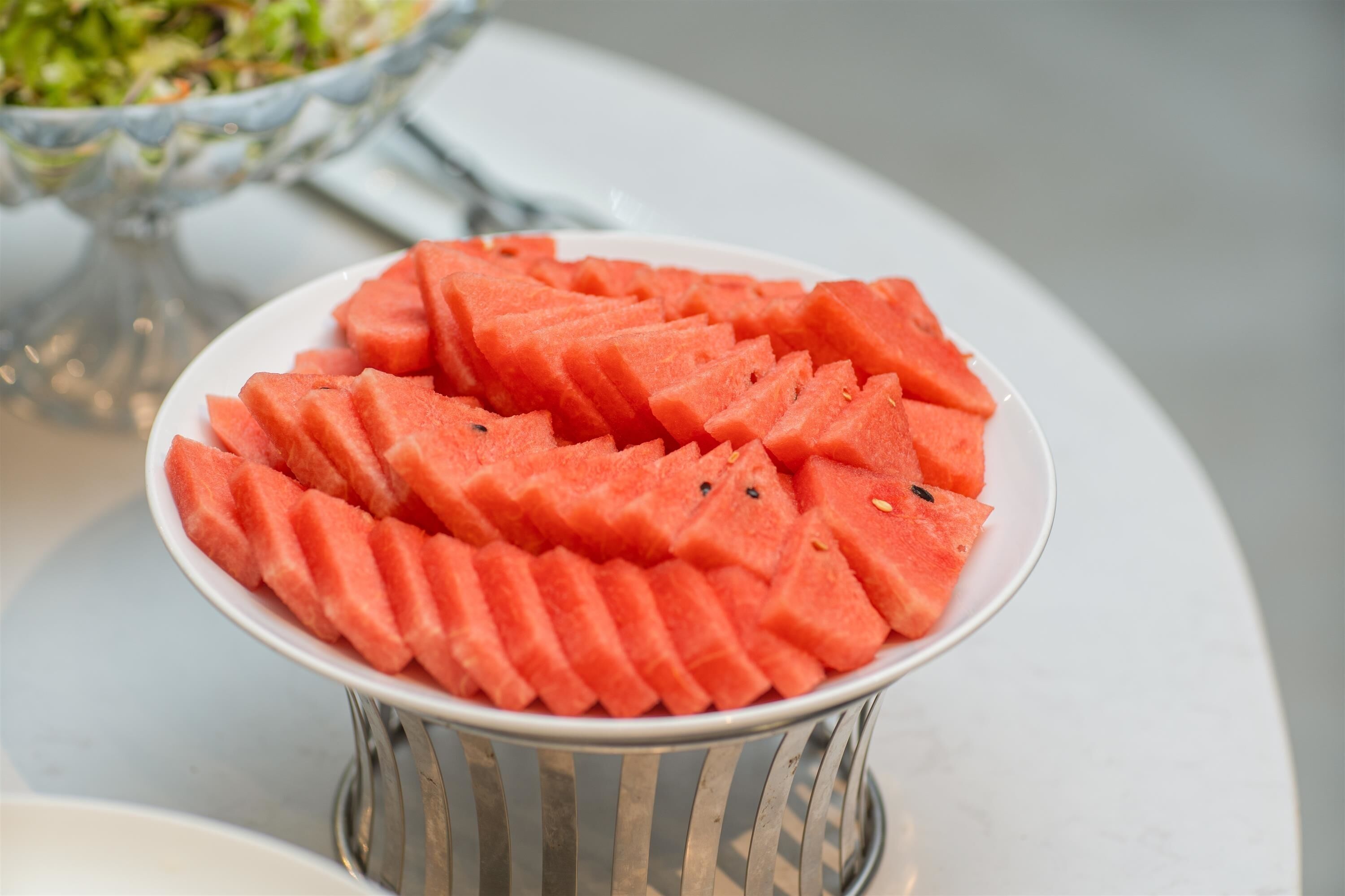 Ein Teller mit Wassermelonenscheiben auf einem weißen Tisch.