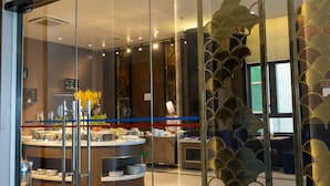 A restaurant with a glass facade and a gold decorative pattern. - Cat Ba Paradise Hotel - Sky Bar & Massage  (Hai Phong)