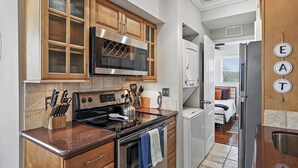 A compact kitchen with wooden cabinets, a stainless steel oven, and a microwave. - Live-Love-St Pete! Hipster 1 bdrm Studio in DTSP!! (St. Petersburg)