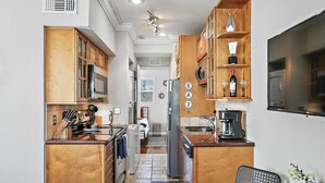 A compact kitchen with wooden cabinets, a built-in oven, and a coffee maker. - Live-Love-St Pete! Hipster 1 bdrm Studio in DTSP!! (St. Petersburg)
