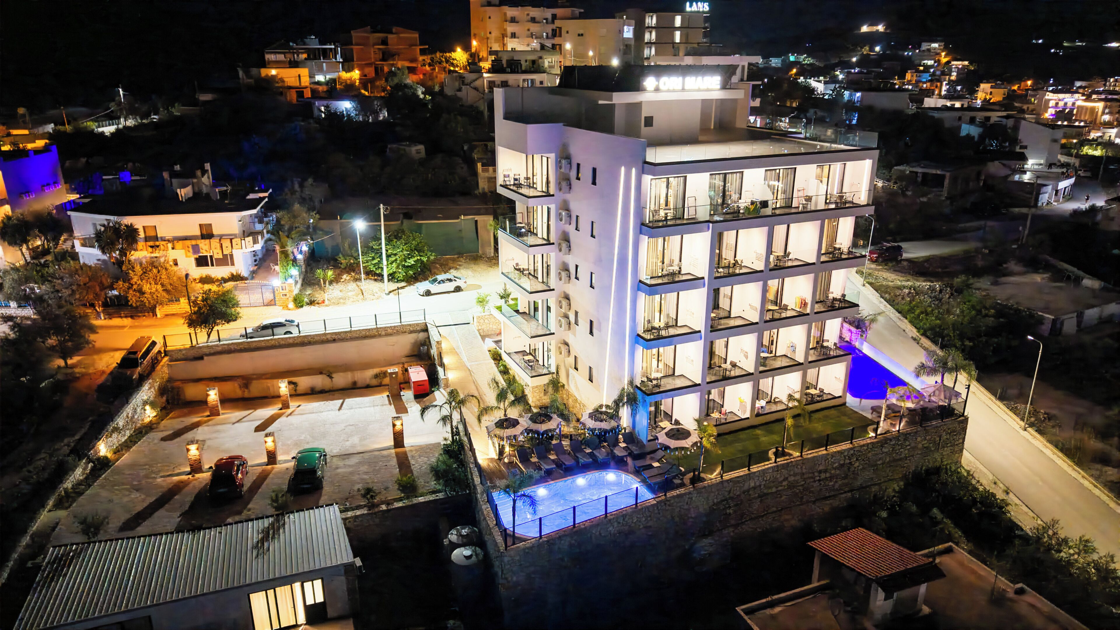 A multi-story hotel with outdoor seating and a swimming pool.