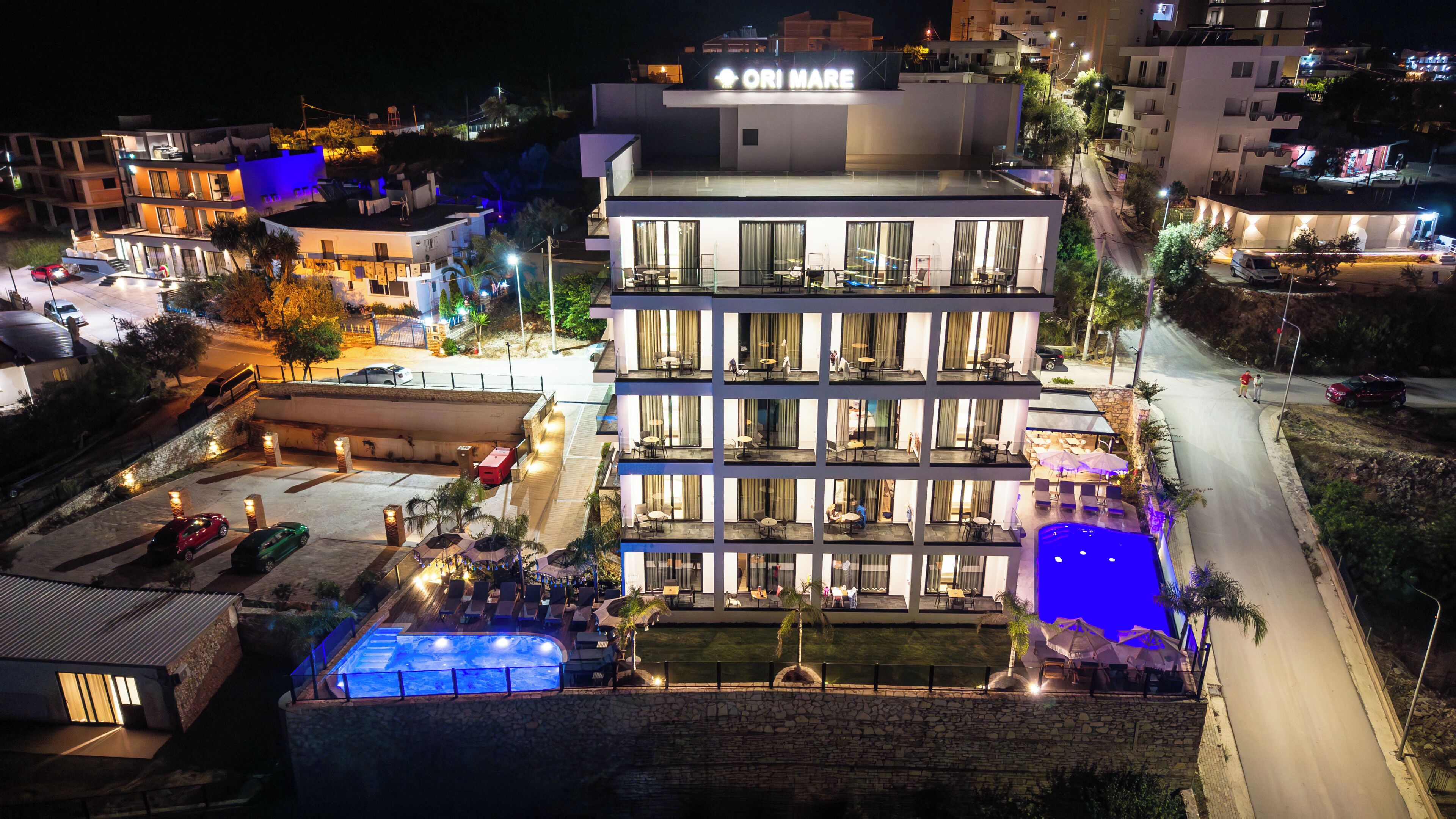 A multi-story hotel with a rooftop pool and outdoor seating.