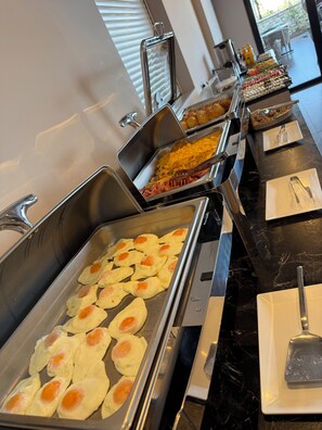 Un bufé con diversos alimentos, entre ellos huevos y una ensalada.