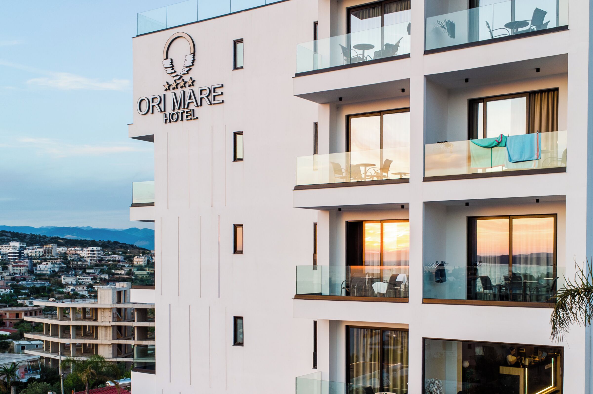 Un hotel de varios pisos con balcones, ventanas amplias y vistas a la ciudad.