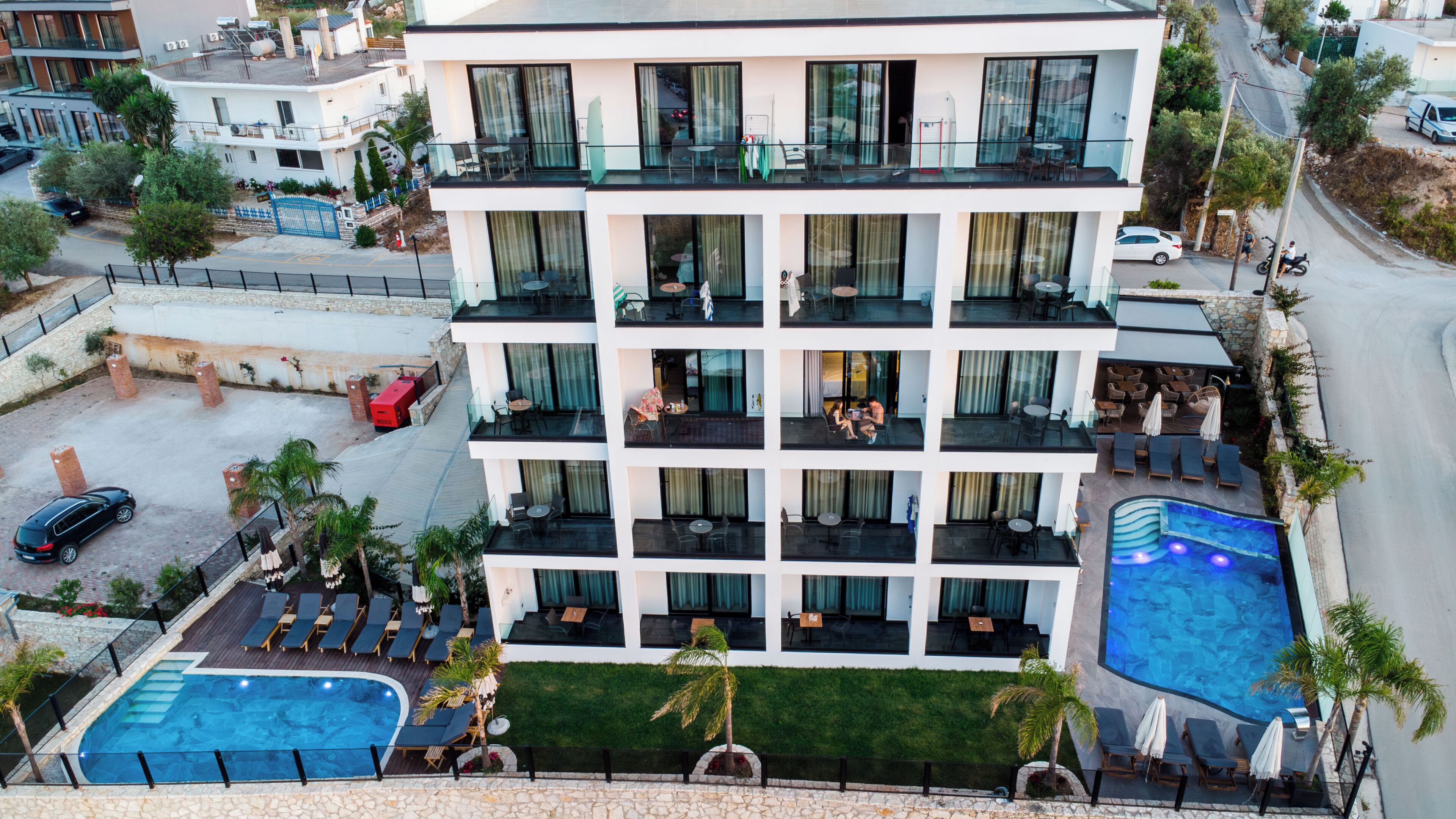 Un hôtel à plusieurs étages doté d’une piscine sur le toit, d’un espace extérieur aménagé et offrant une vue sur les environs.