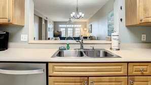 Una cucina moderna con mobili in legno, un lavello in acciaio inossidabile e una ventola a soffitto.