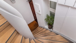 A spiral staircase with wooden steps and white walls.