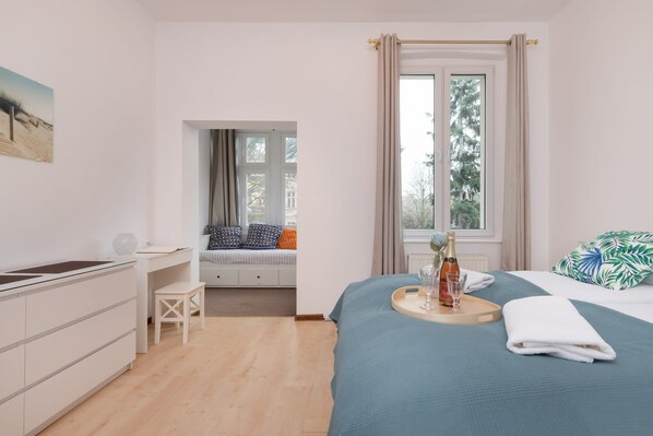 Another angle of the bedroom with blue bedding, highlighting the airy atmosphere.