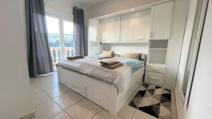 Un dormitorio con cama, armarios empotrados y vistas al exterior por una ventana.