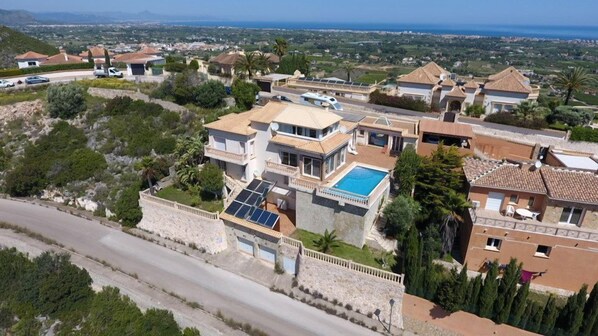 A residential area with houses, a swimming pool, and solar panels.