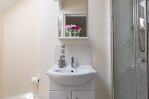 Ein Badezimmer mit Waschbecken, Spiegel und Dusche.